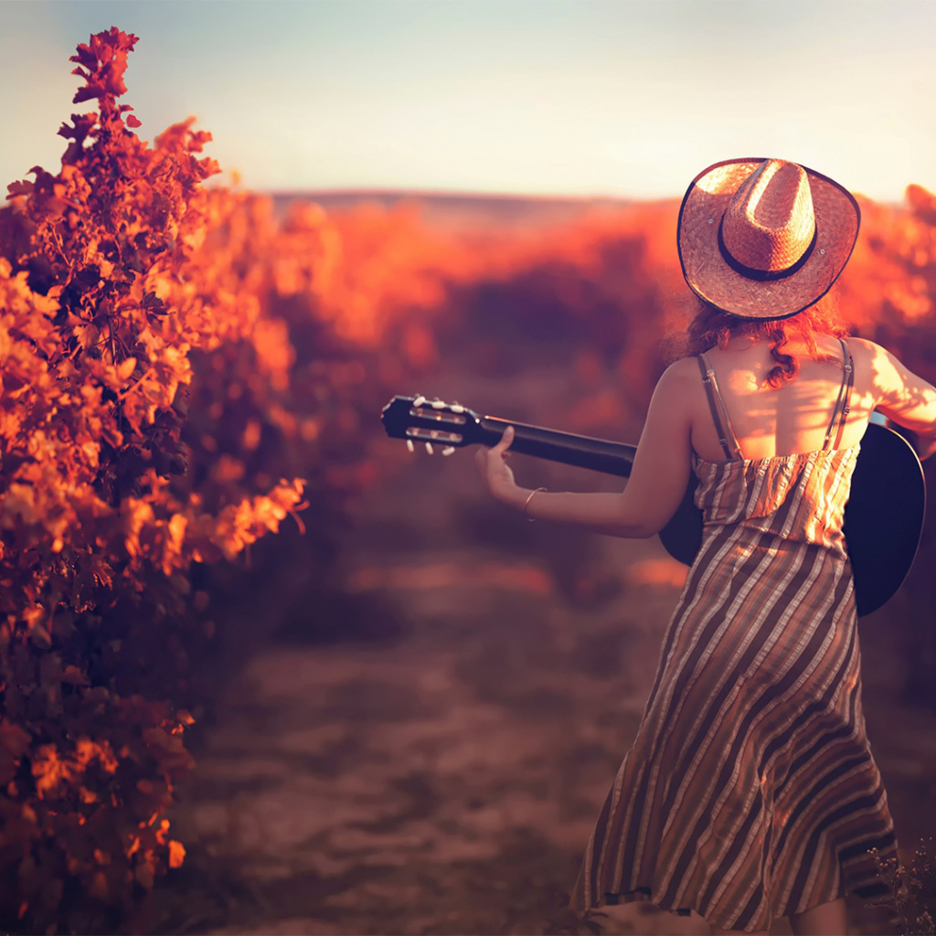 Девушка с гитарой в винограднике