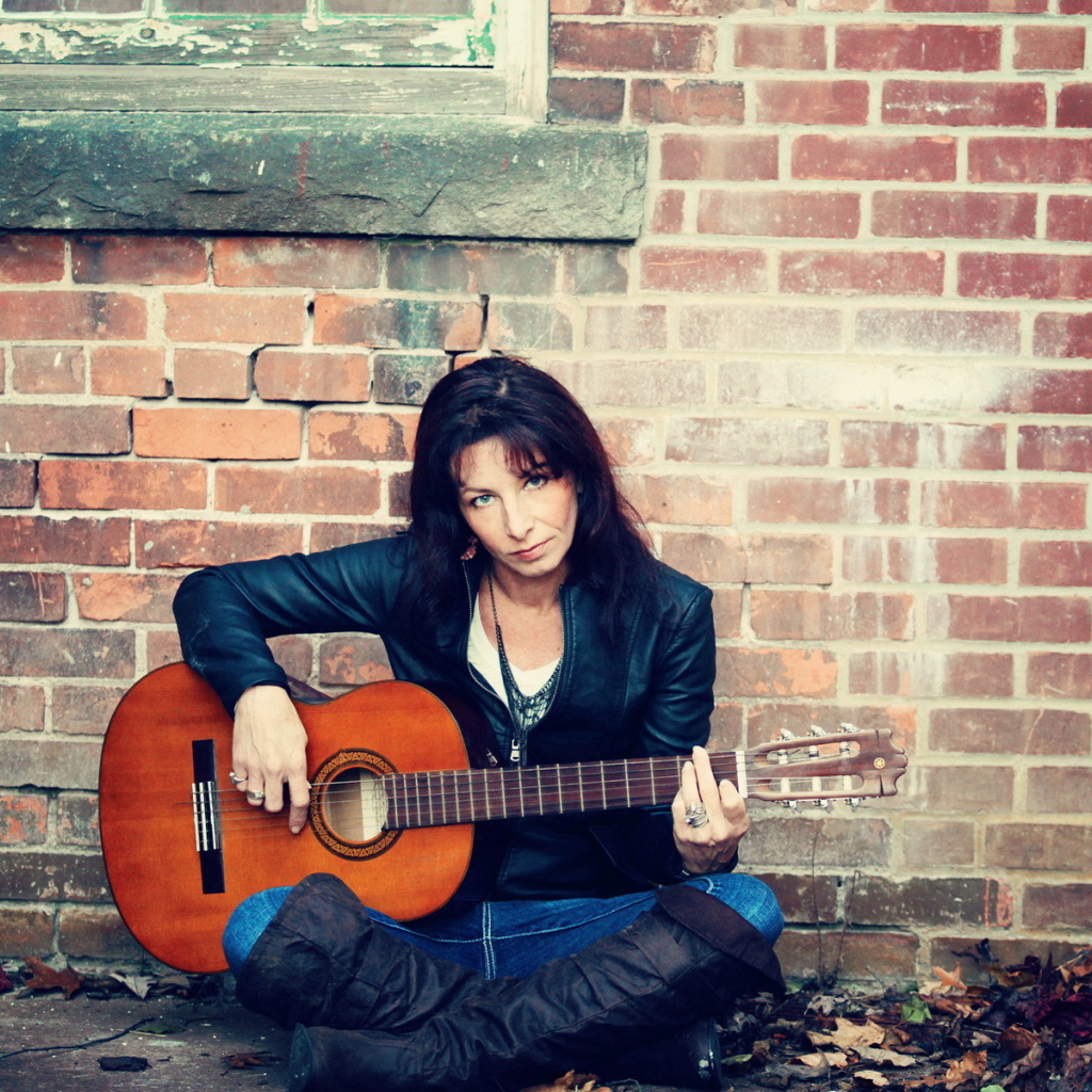 Девушка с гитарой у стены