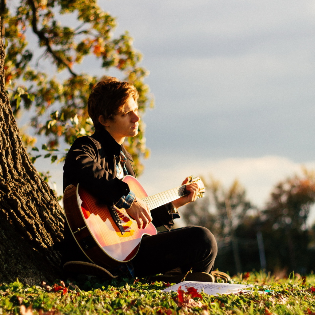 Парень с гитарой у дерева