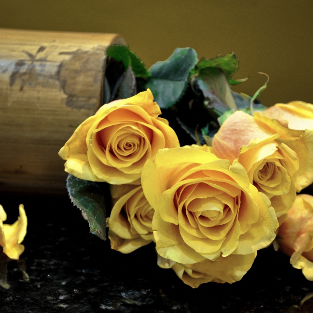 Жёлтые розы на тёмном столе