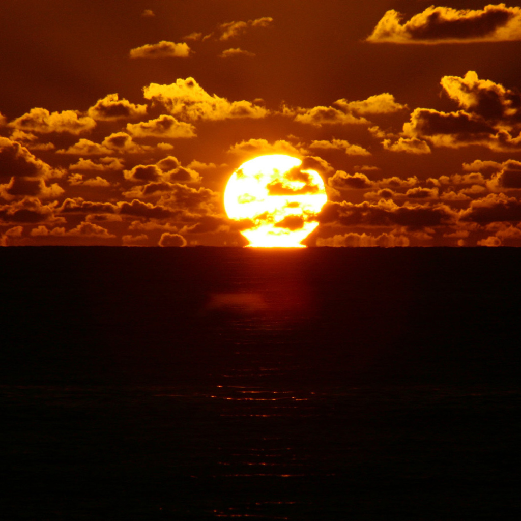Солнце между небом и морем