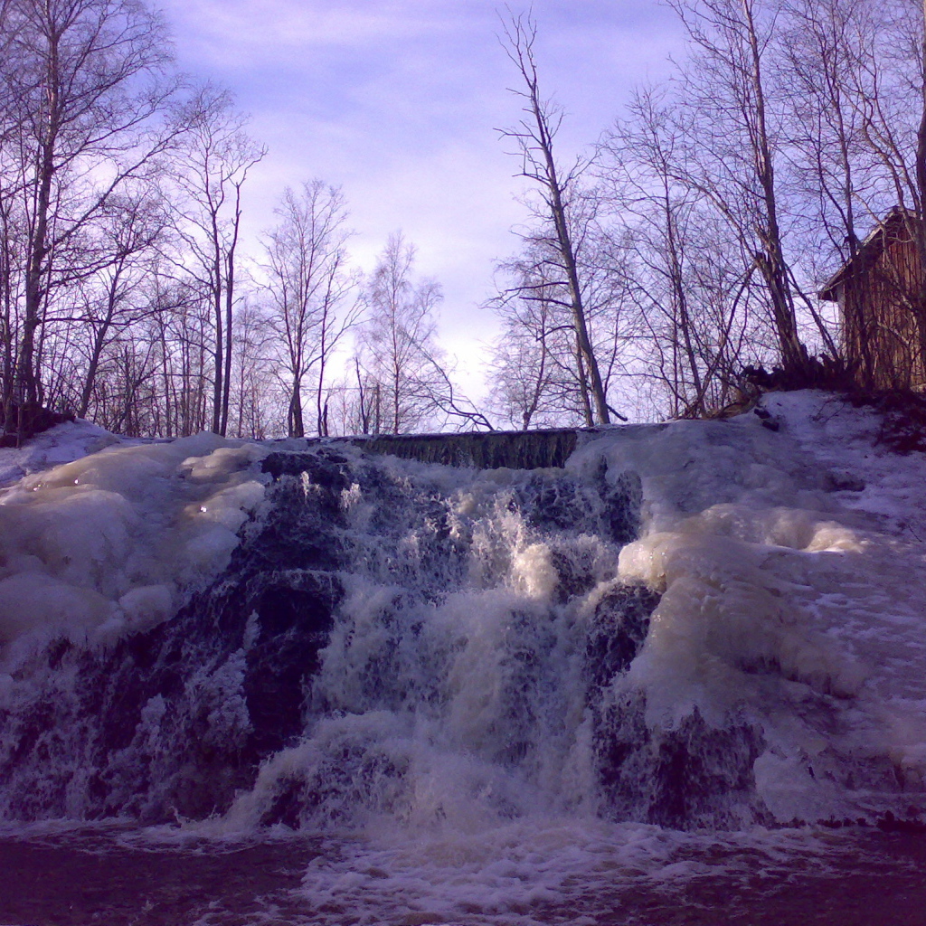 Замерзший водопад и хижина лесника