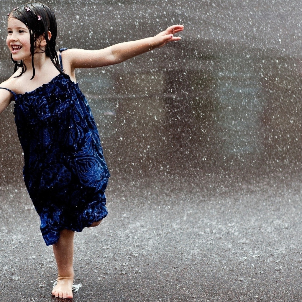 Счастливый ребенок бегает под дождем