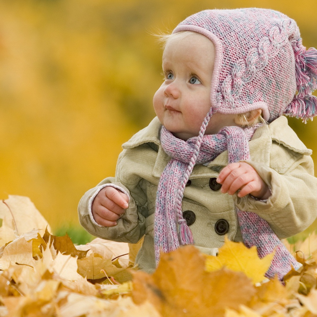 Ребенок играет осенними листьями