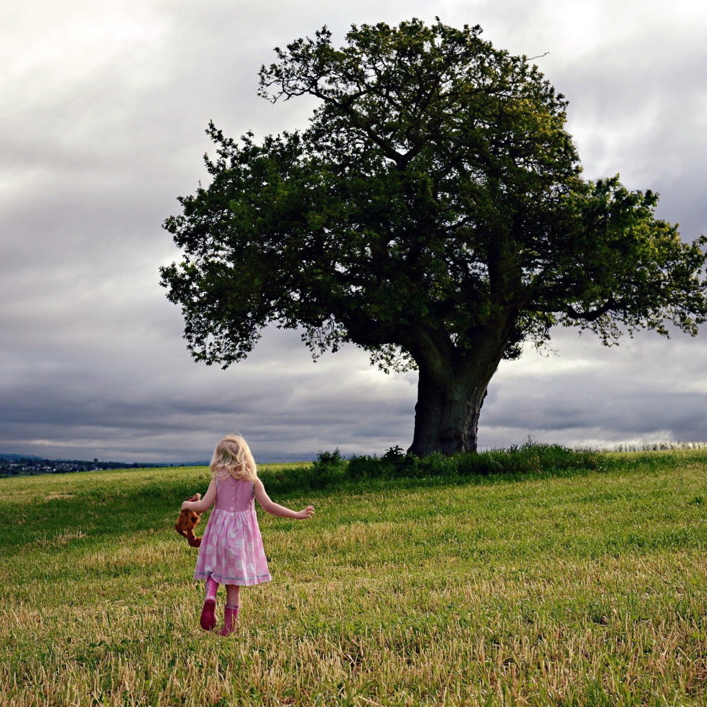 Маленькая девочка бежит к дереву