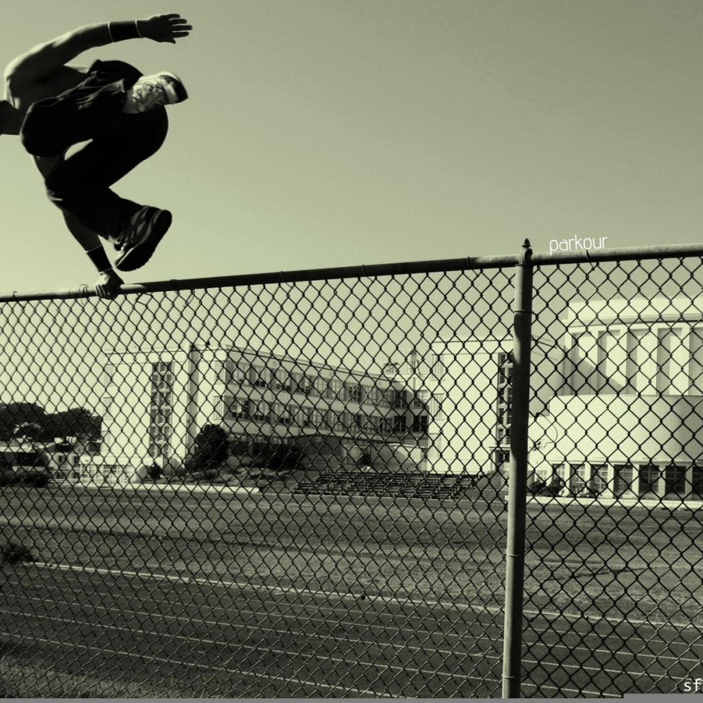 Паркурщик прыгает через забор