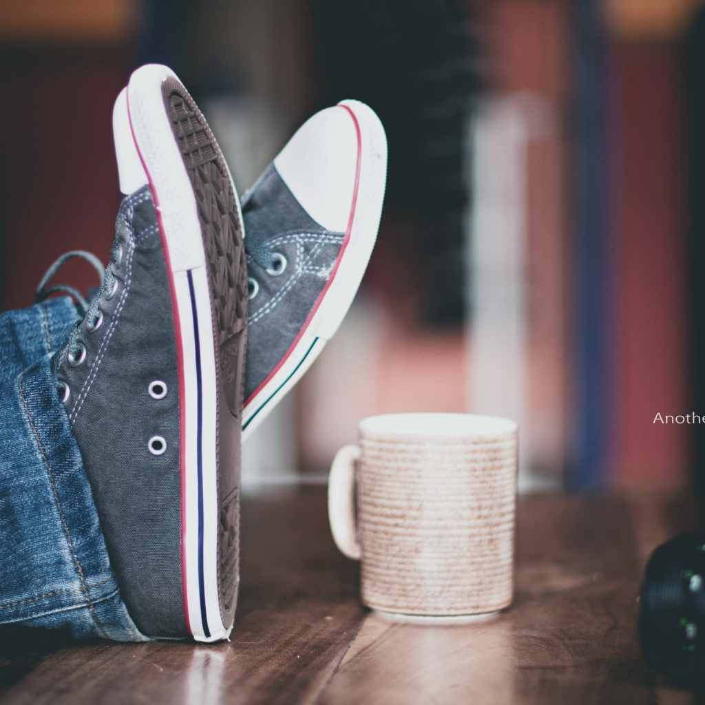 Кеды и чашка на столе