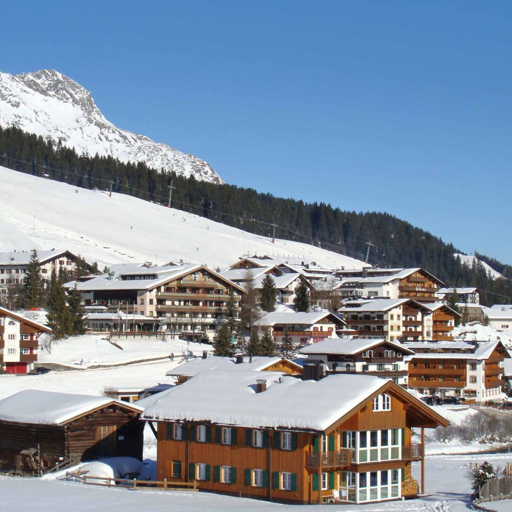 Дома на фоне гор на горнолыжном курорте Лех, Австрия