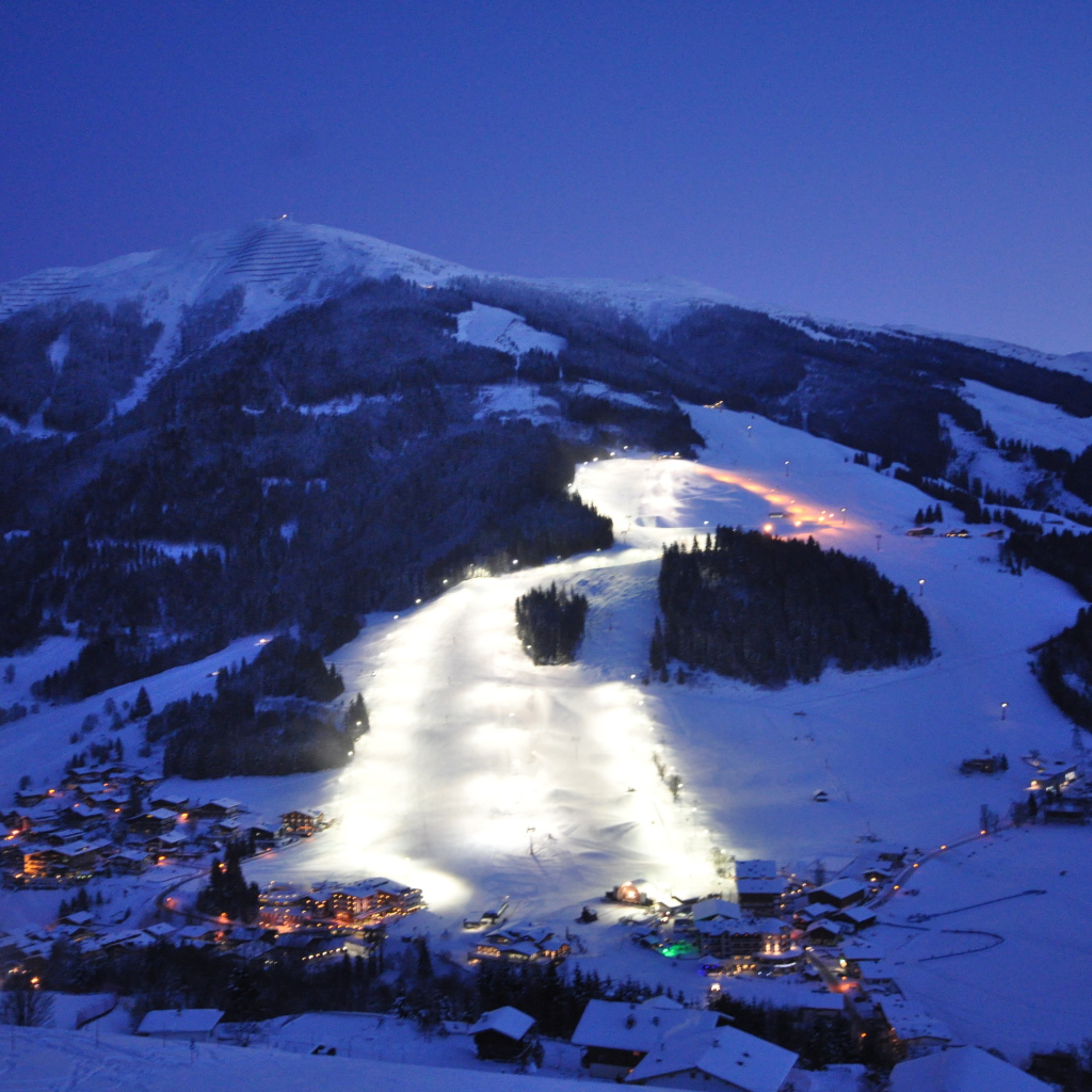 Вечерняя подсветка лыжной трассы на горнолыжном курорте Заальбах Хинтерглем, Австрия