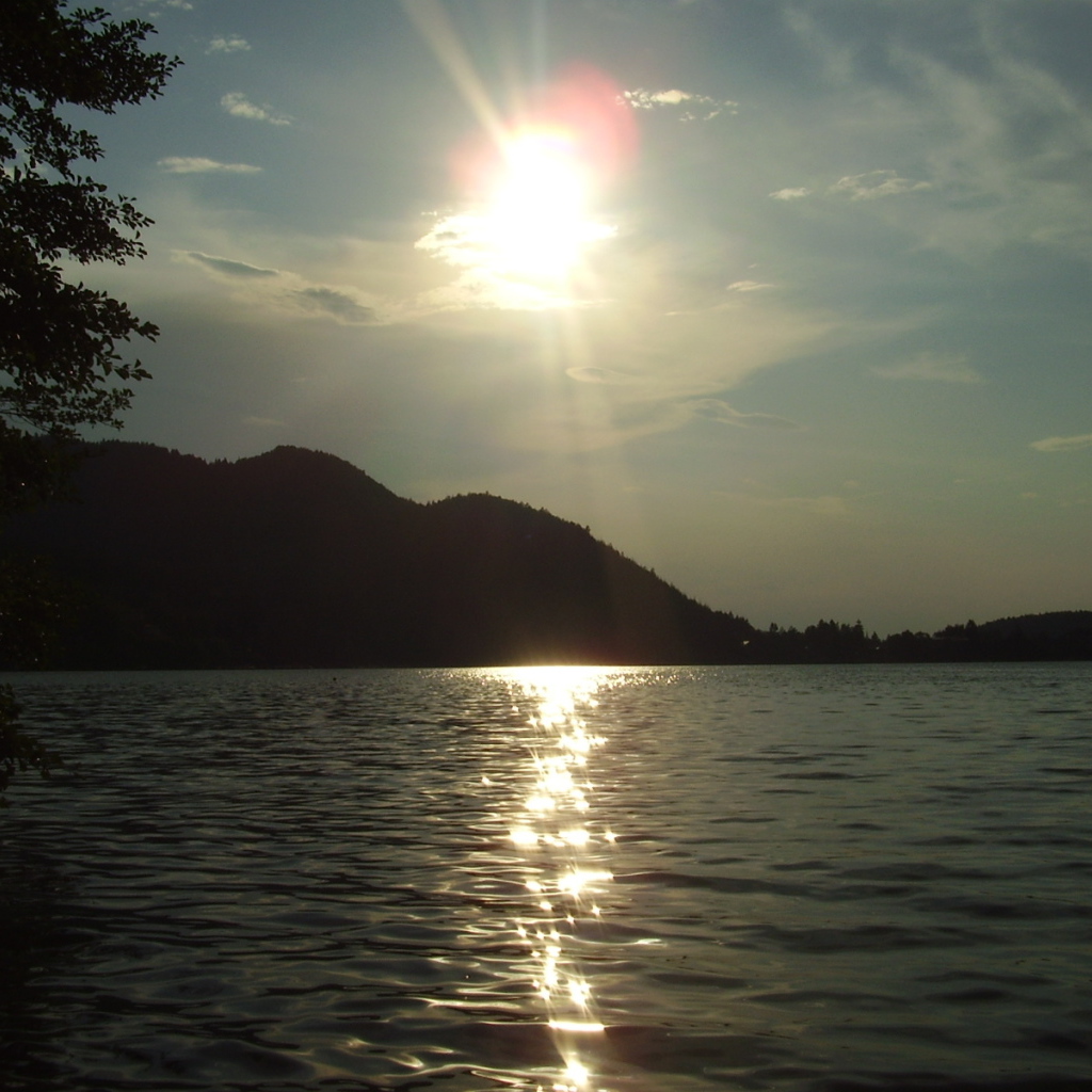 Солнце над водой озера Клопайнер Зее, Австрия