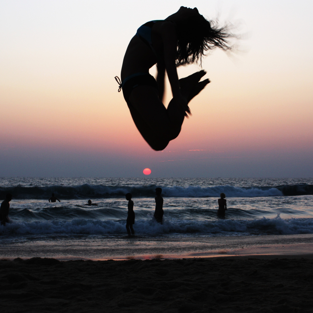 Девушка в прыжке на пляже в Варкале