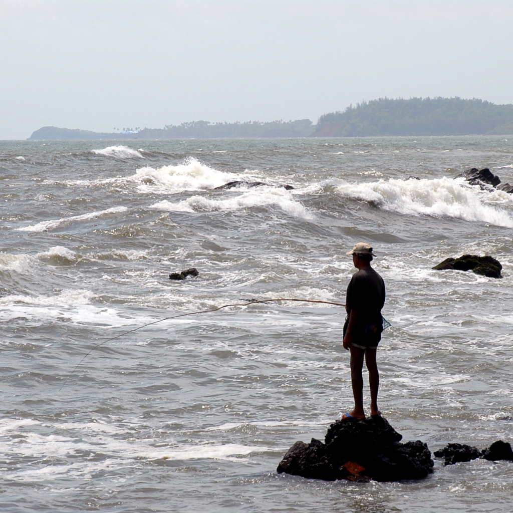 Мужчина ловит рыбу в Гоа