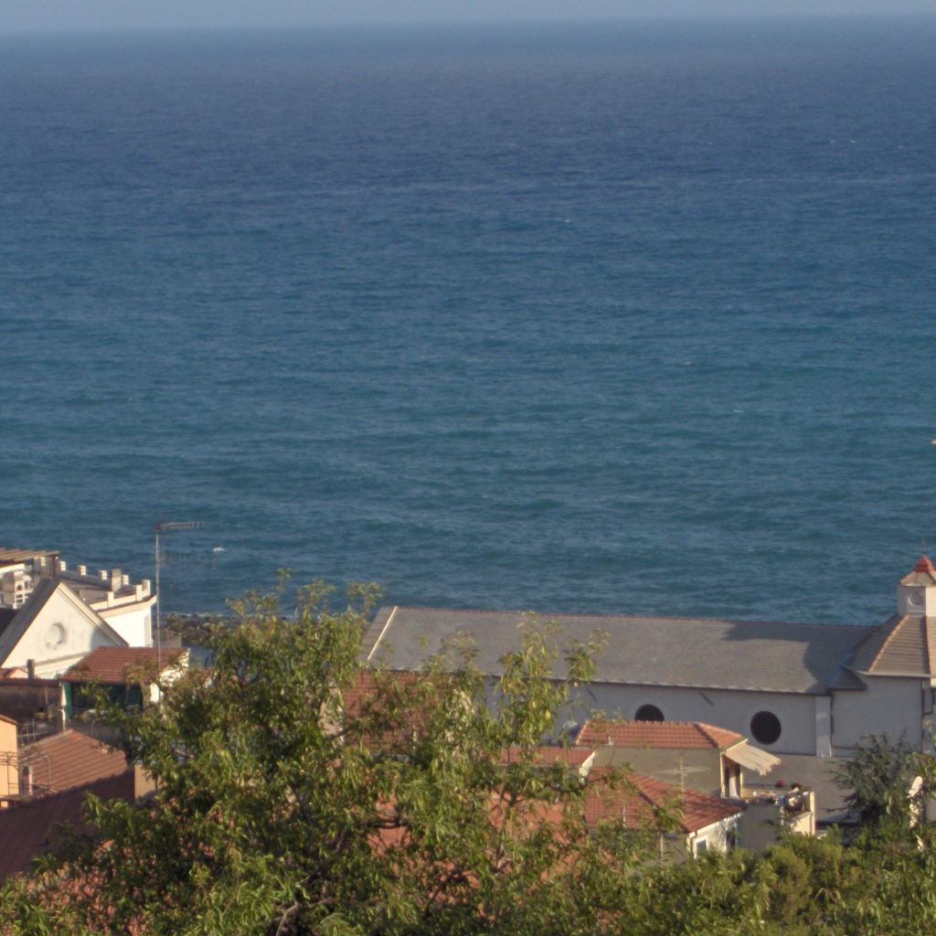 Башня с часами на фоне моря в Санто Стефано аль Маре, Италия