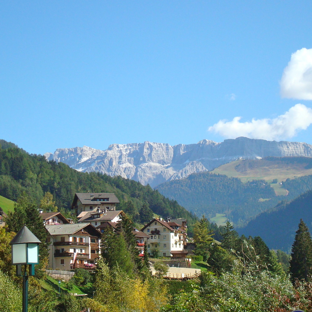 Дома на склоне горы на курорте Ортизей, Италия