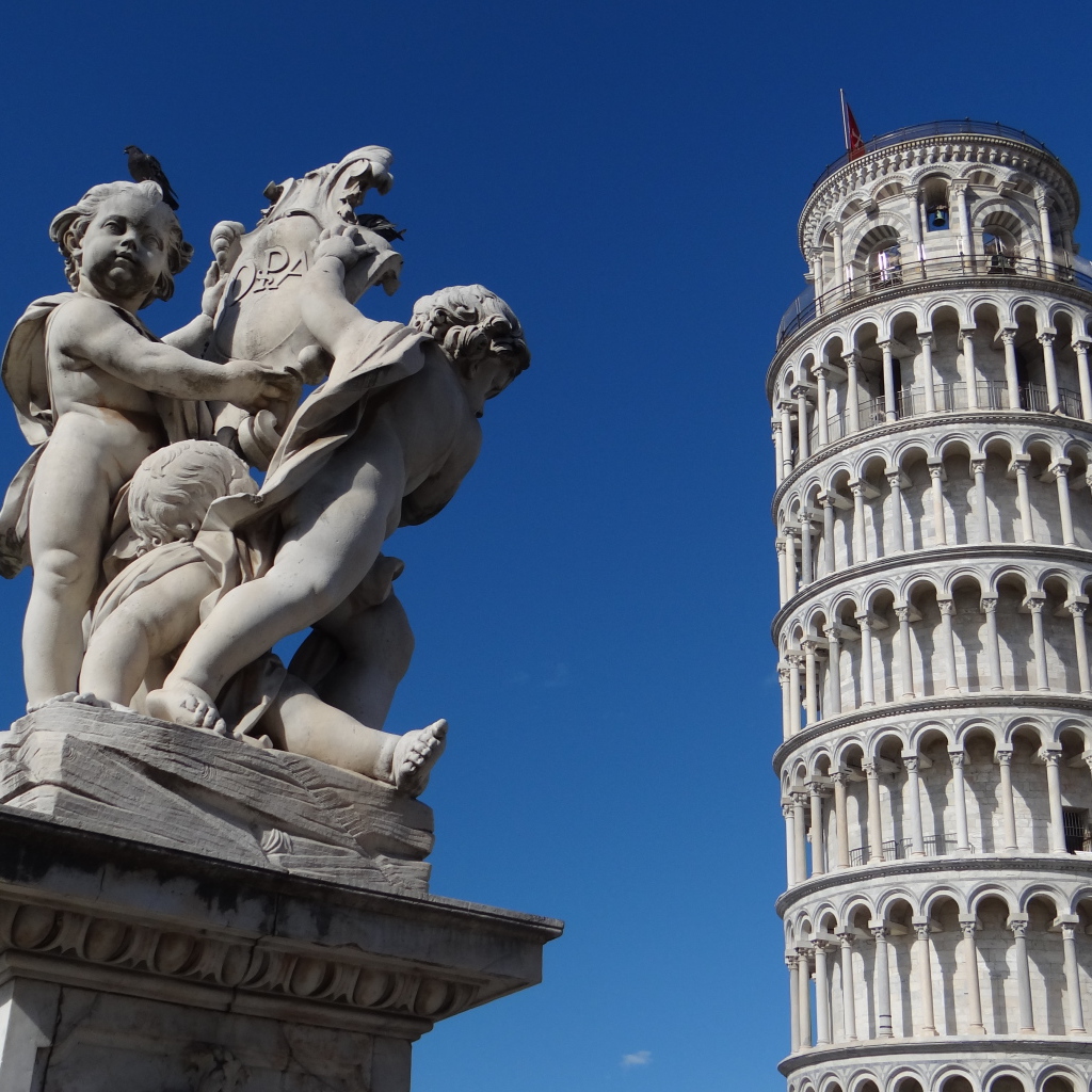 Статуя на фоне башни в Пизе, Италия