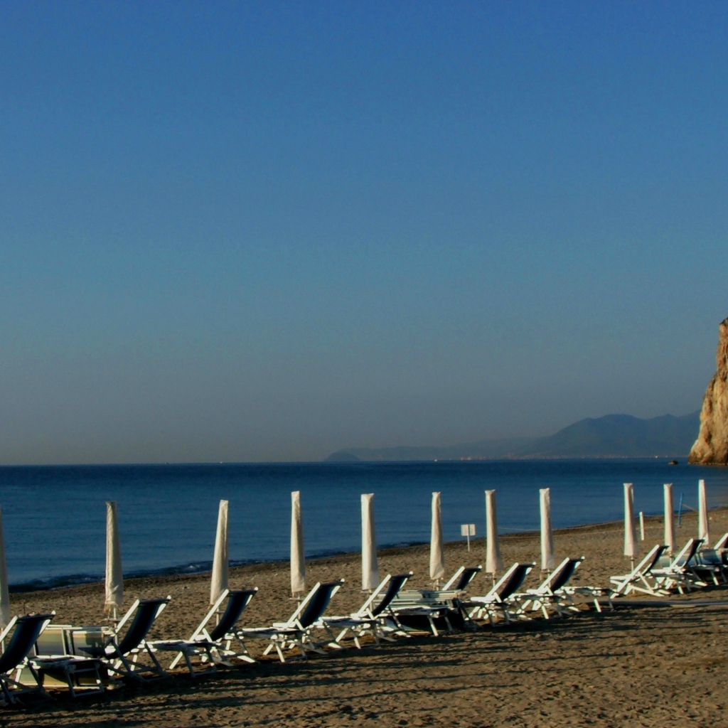 Лежаки на пляже на курорте Финале Лигуре, Италия