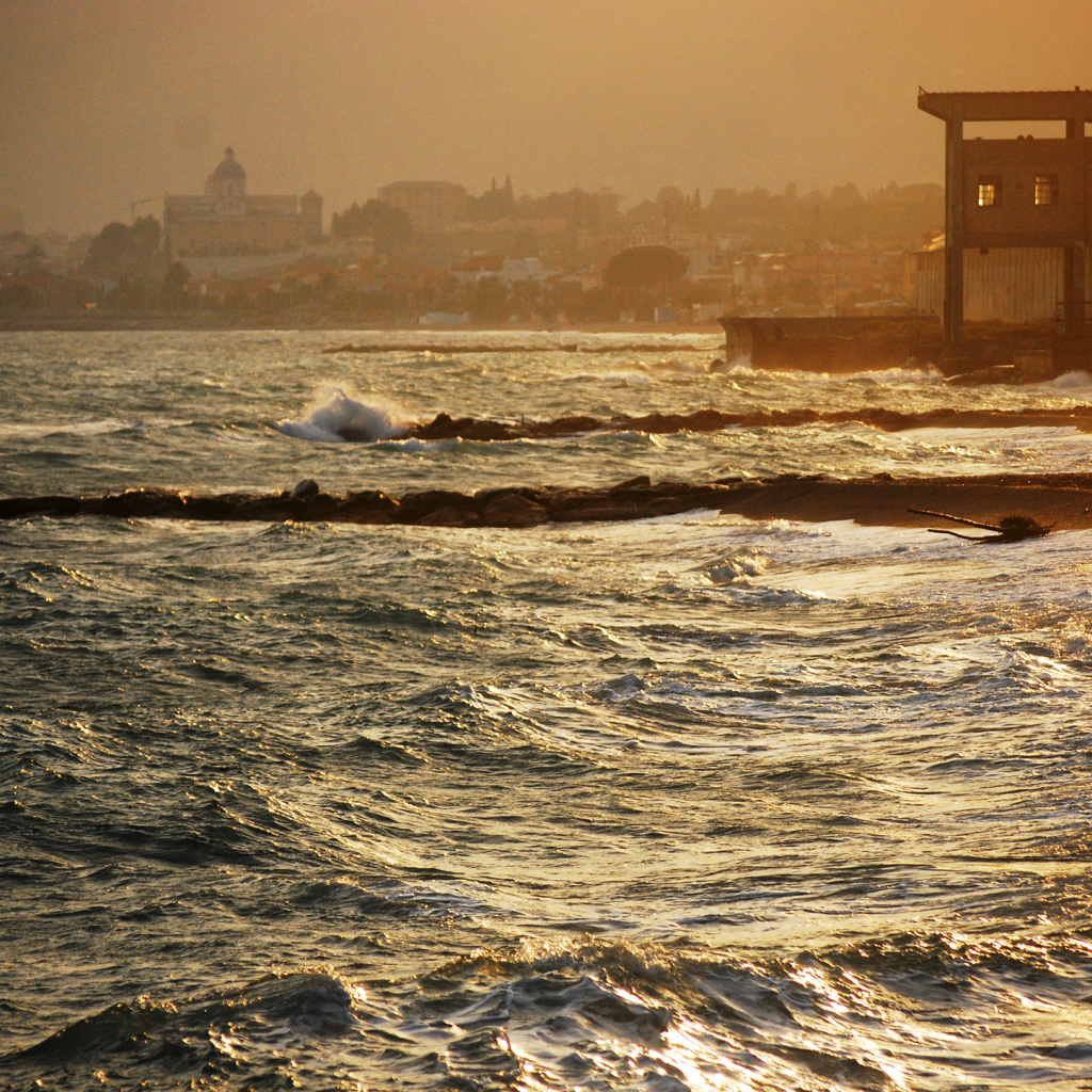 Закат на пляже на курорте в Пьетра Лигуре, Италия