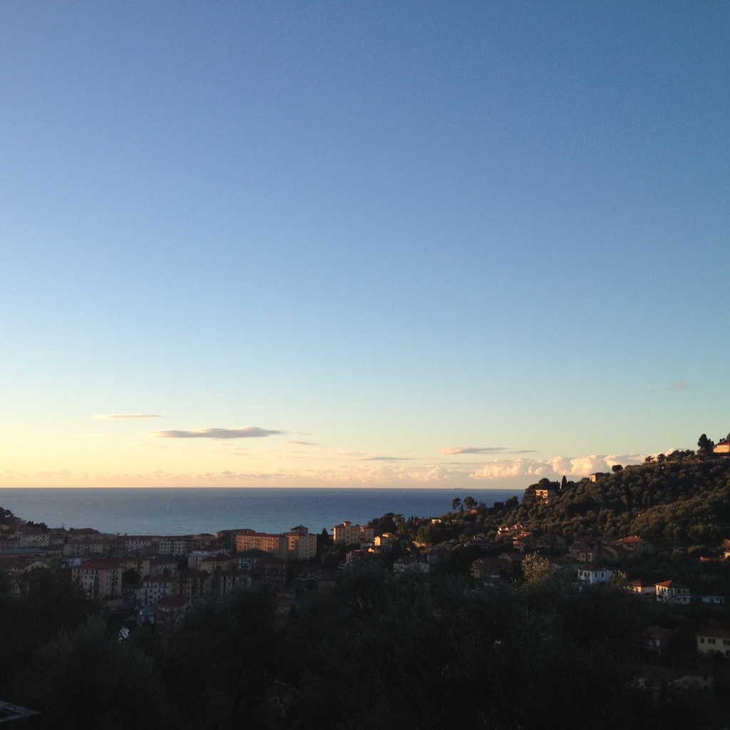 Закат над городом на курорте Империя, Италия