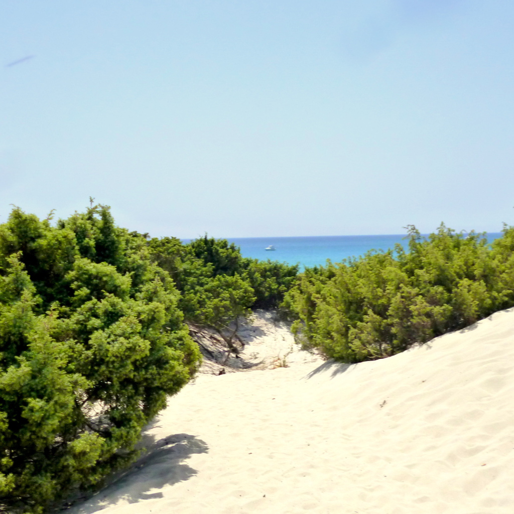 Белый песок на пляже на курорте Вилласимиус, Италия