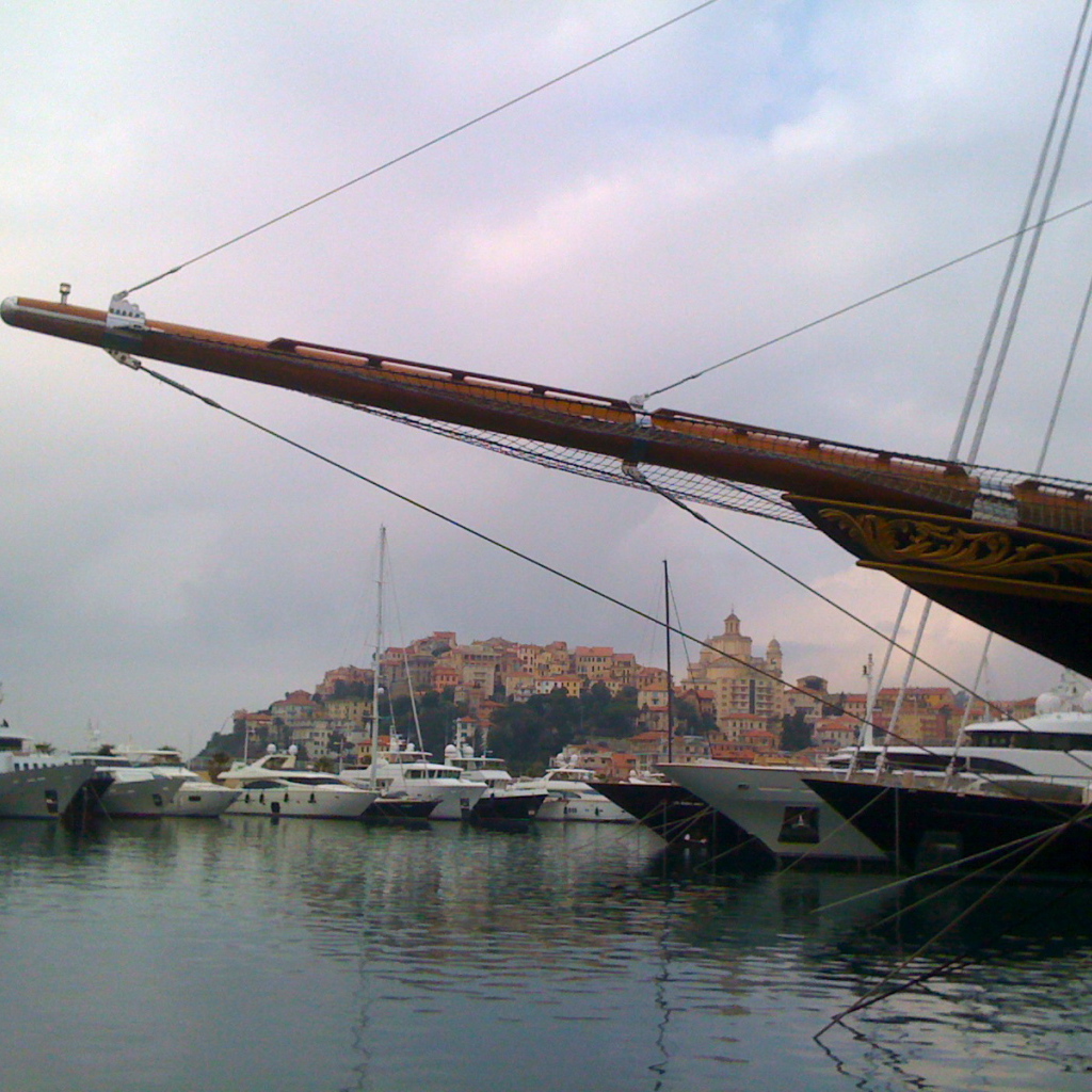 Яхта на фоне города на курорте Империя, Италия