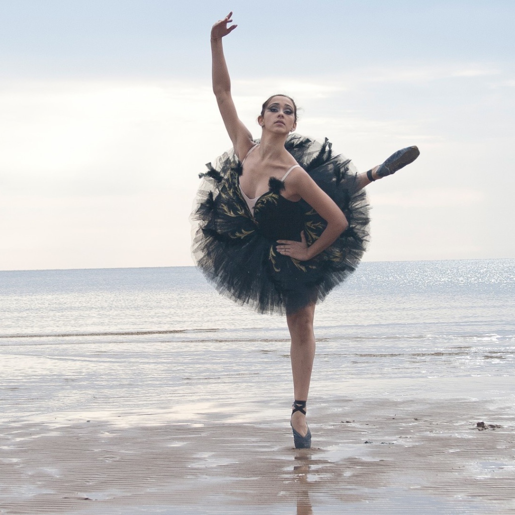 Балерина в черном на пляже