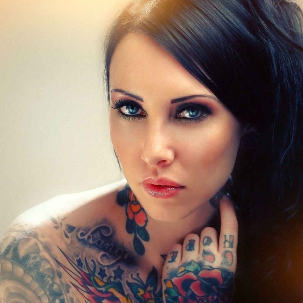 Голубоглазая девушка с татуировкой на руке и плече