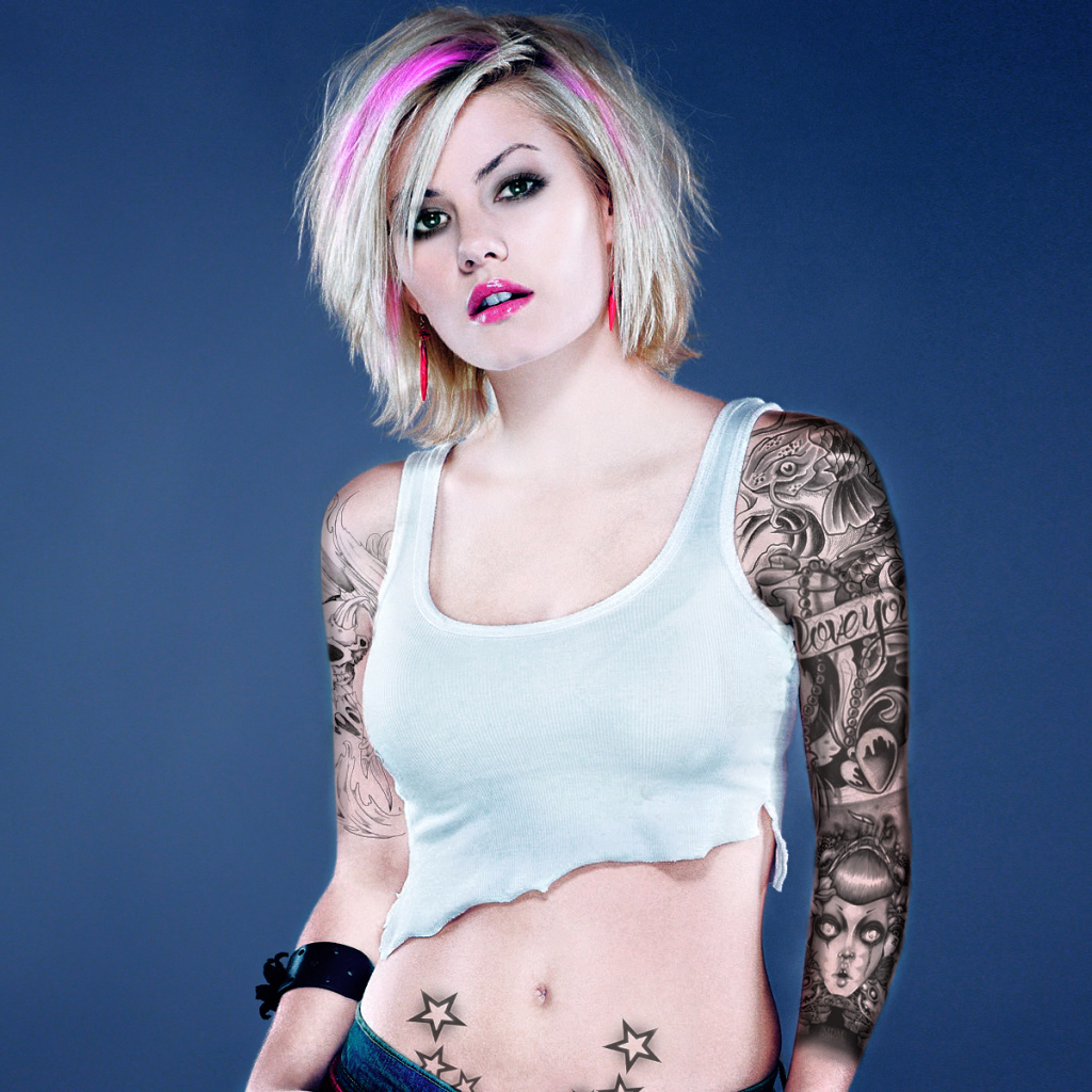 Девушка бунтарка с татуировками на руке и животе