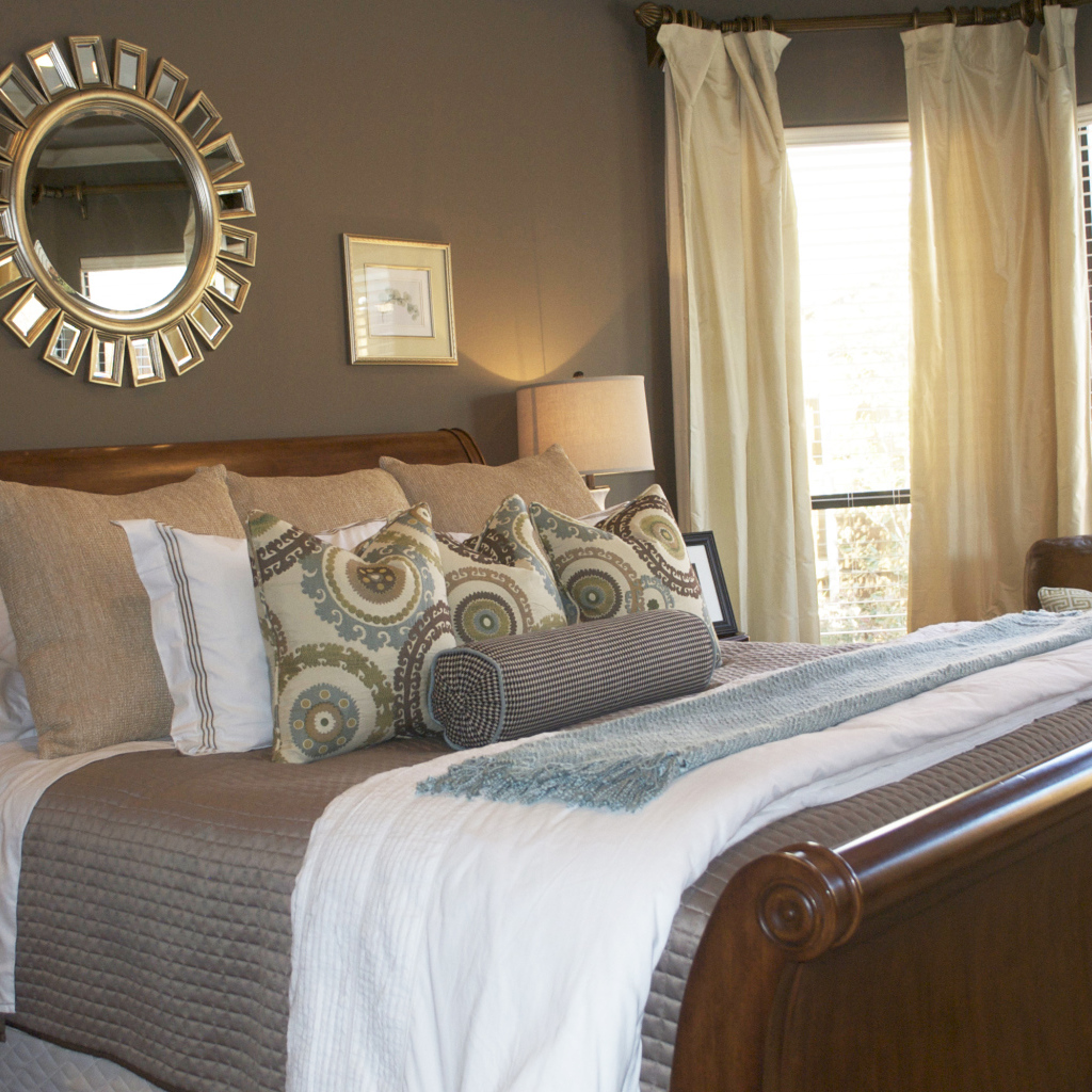 Круглое зеркало над кроватью в спальне