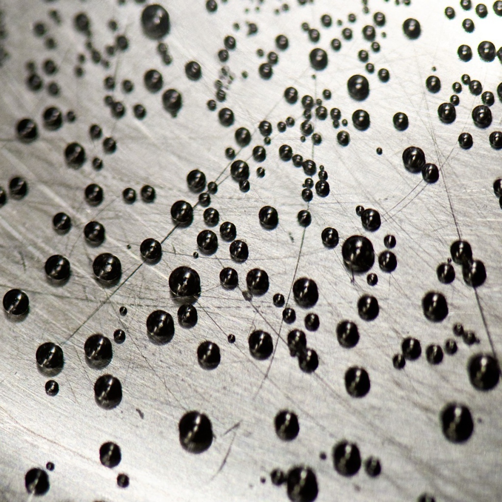 Мелкие черные шарики на серой поверхности