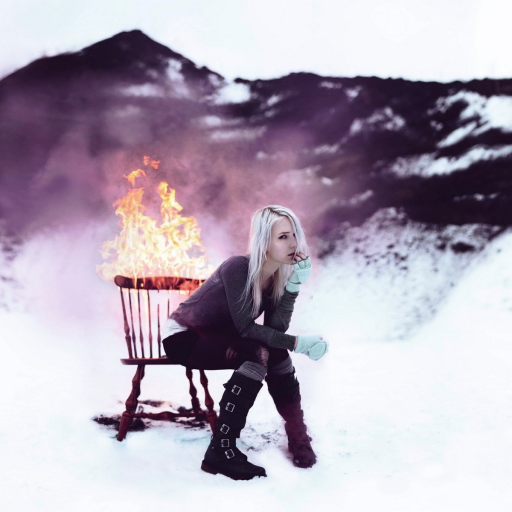 Девушка сидит на горящем стуле