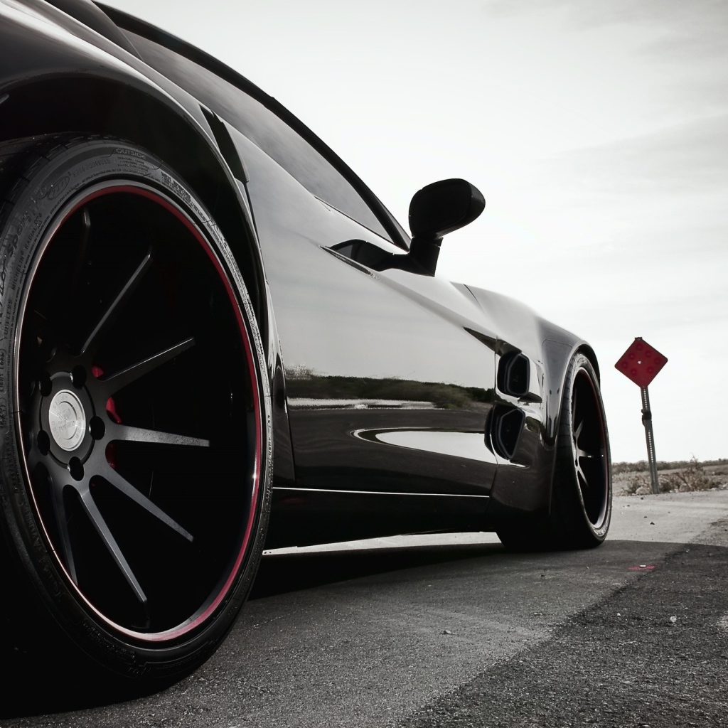 Черный автомобиль перед дорожными знаками