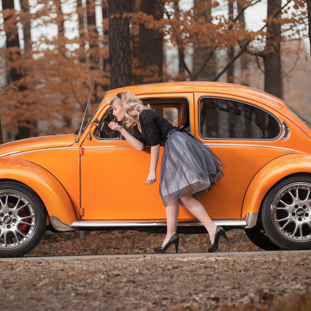 Девушка красит губы у зеркала старого автомобиля