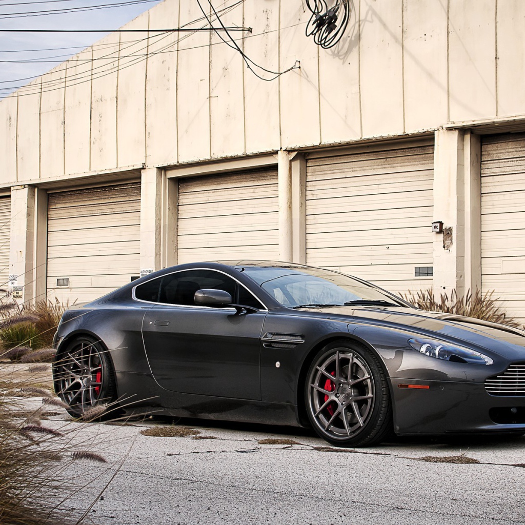 Автомобиль Aston Martin у складского здания