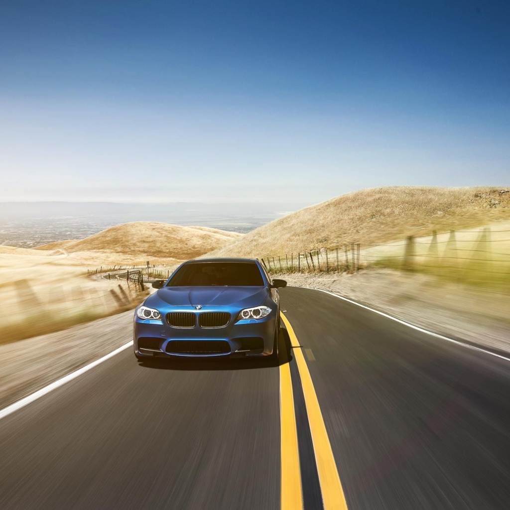 Голубой BMW мчится по шоссе в пустыне