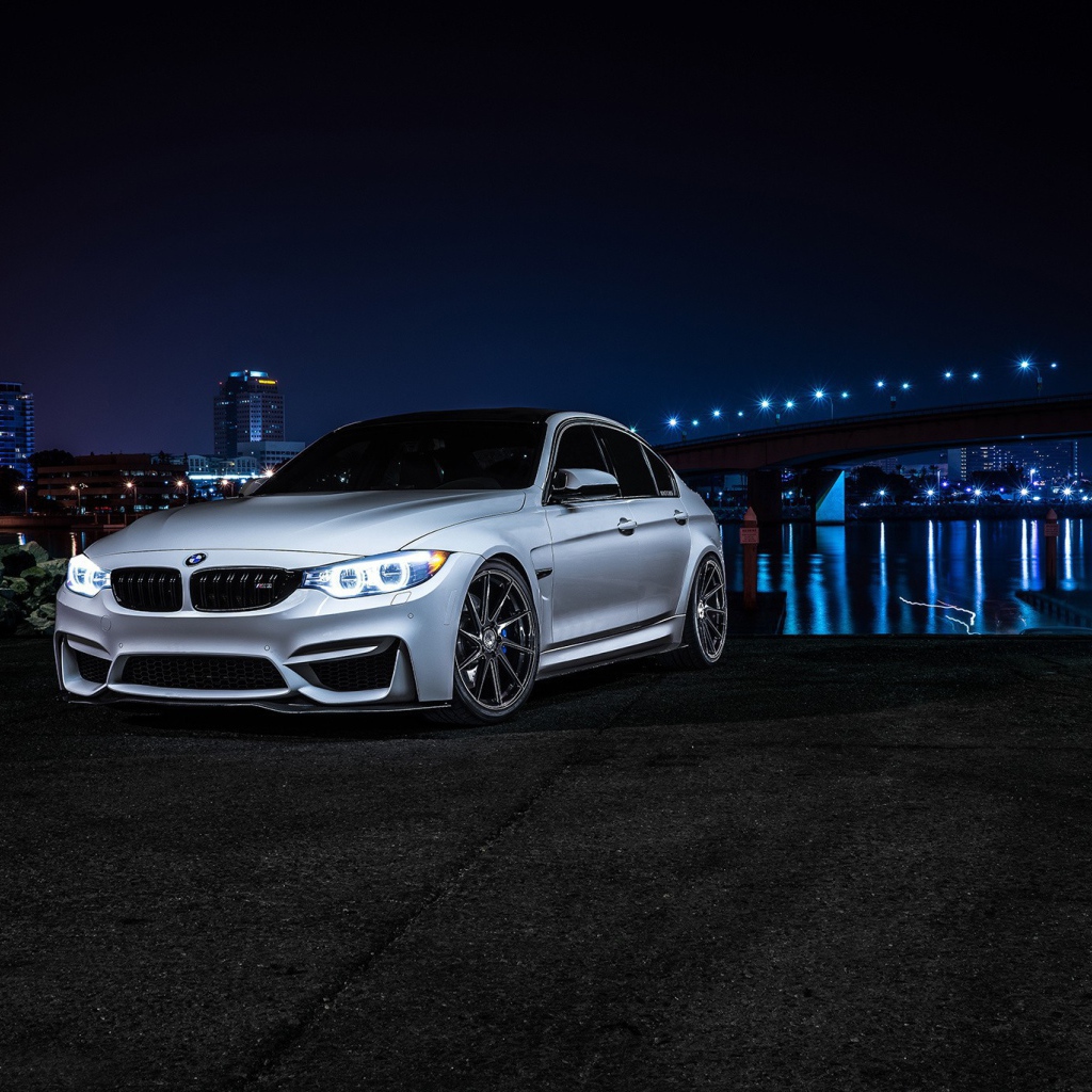 Серебристый BMW на фоне ночных огней