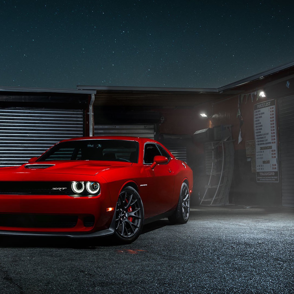 Красный Dodge Challenger Hellcat у гаража