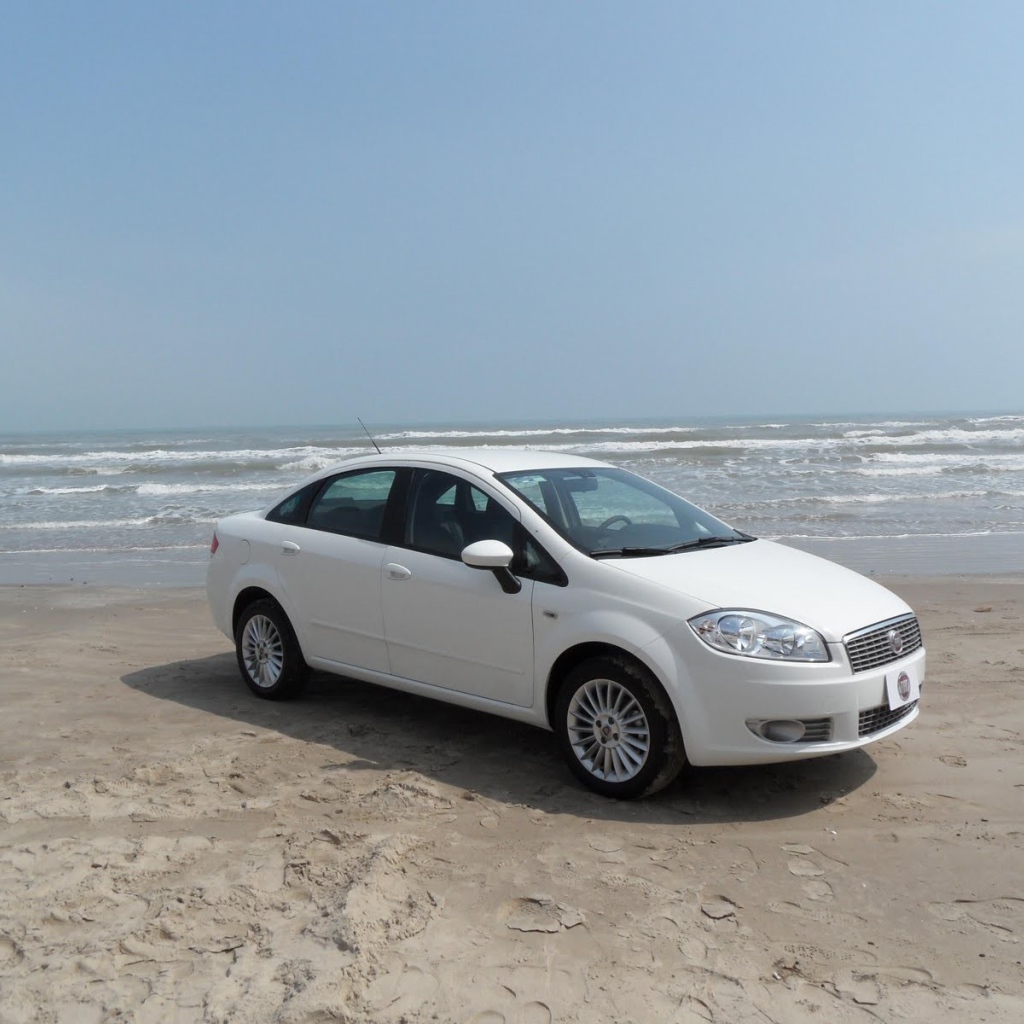Белый Фиат на песке пляжа