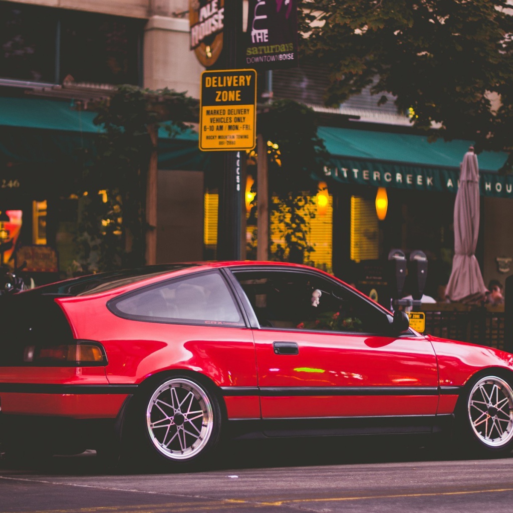 Красная Honda CRX стоит у уличного кафе
