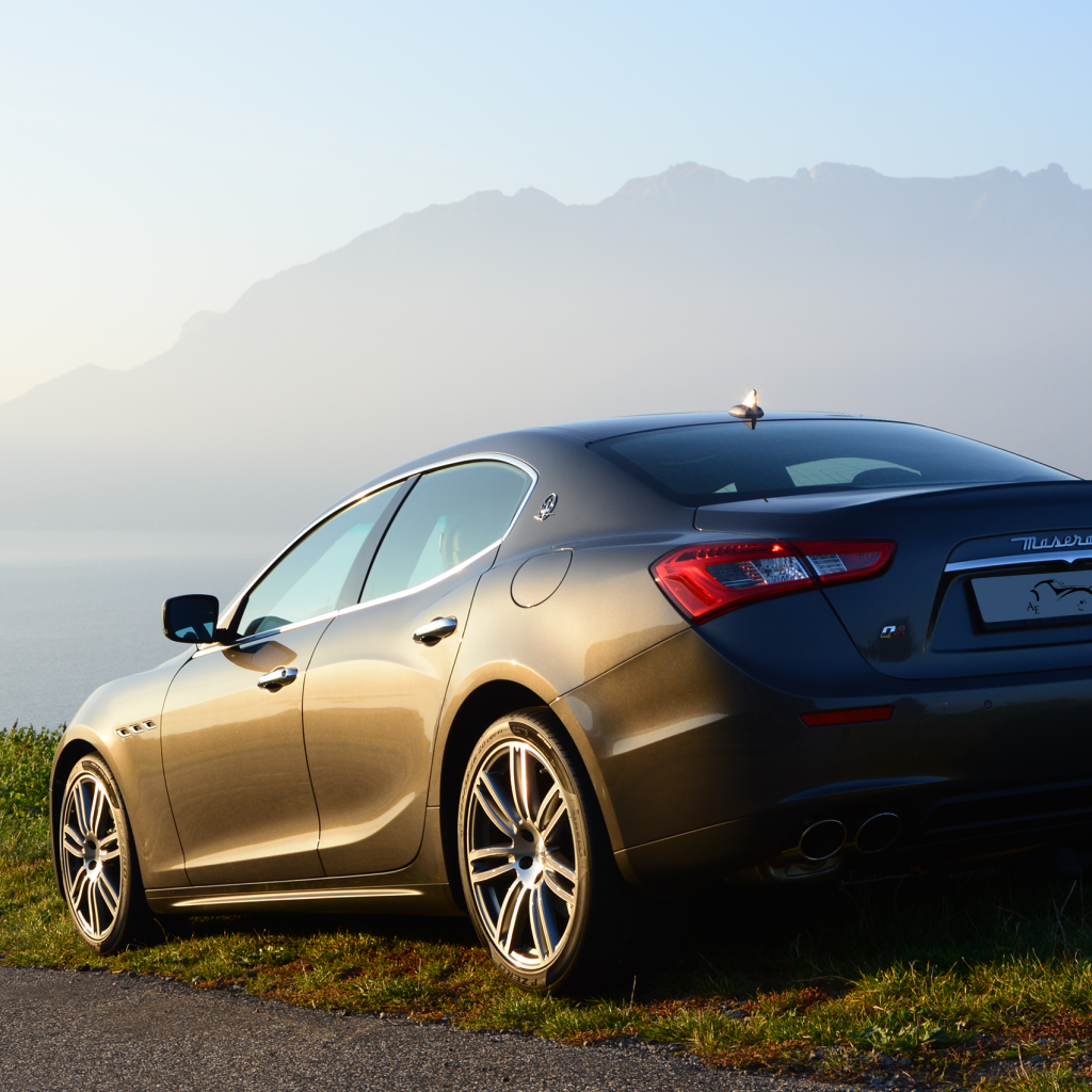 Коричневый Maserati на фоне гор