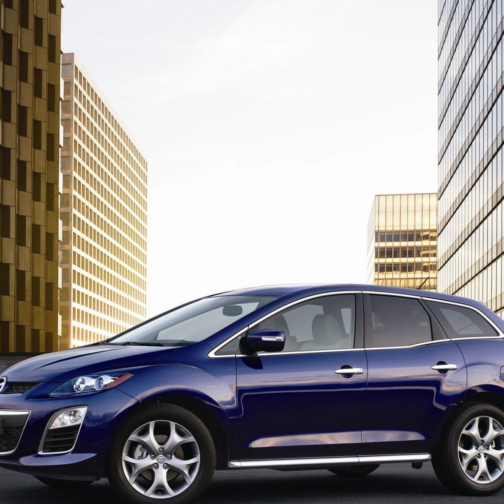 Семейный автомобиль Мазда на фоне городских зданий