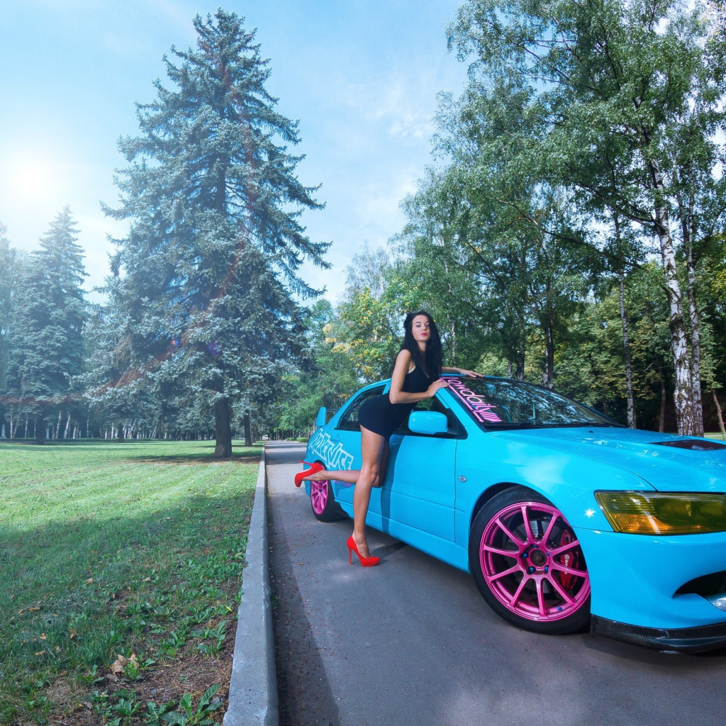 Девушка облокотилась на голубой Mitsubishi Lancer Evo X