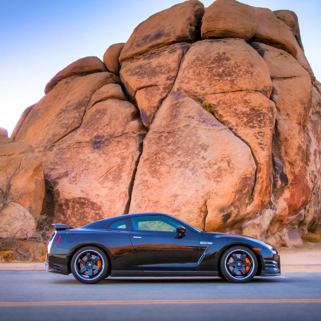 Черный Nissan GT-R у подножия скалы