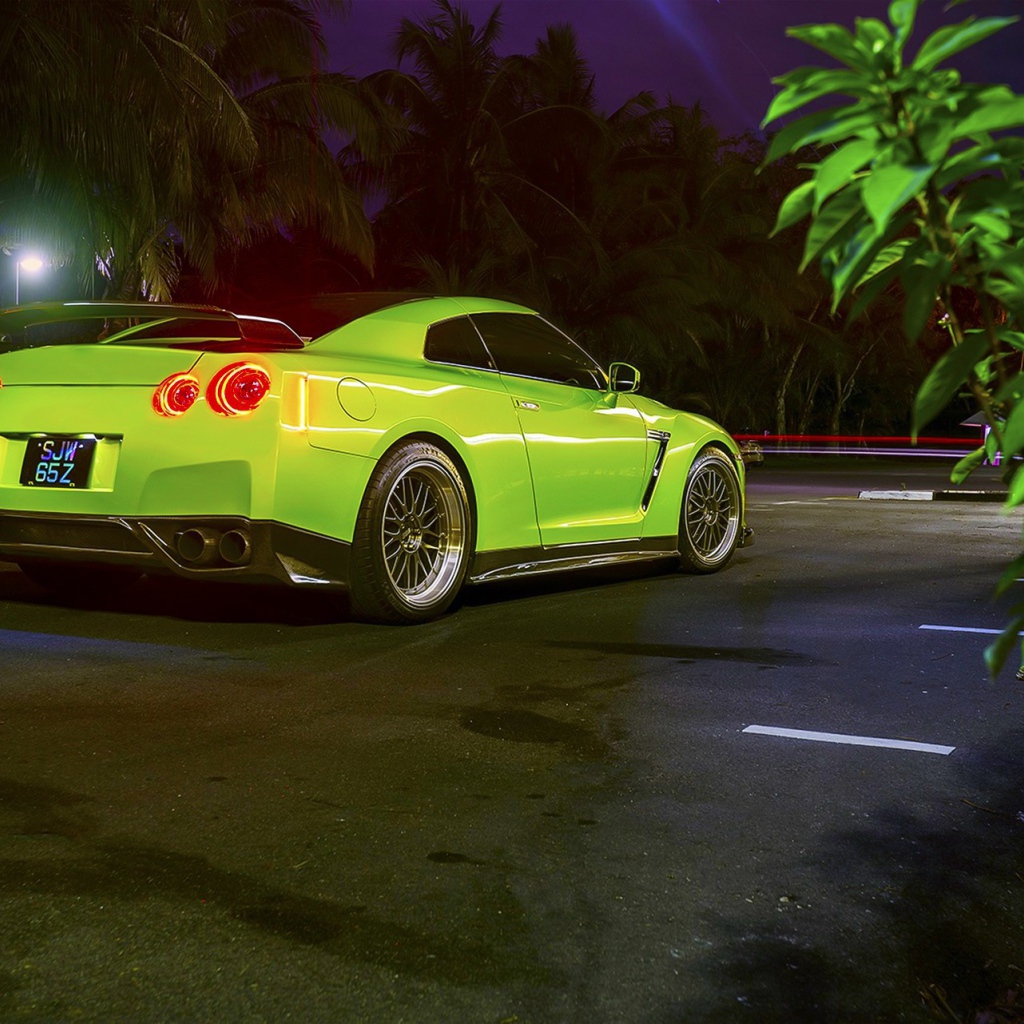 Зеленый спортивный Nissan на ночной улице города