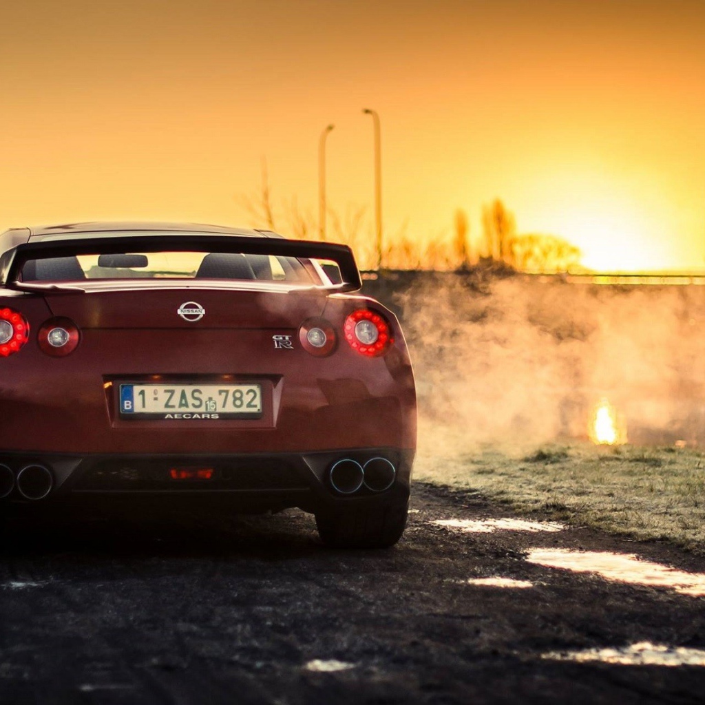 Красный Nissan у реки на рассвете