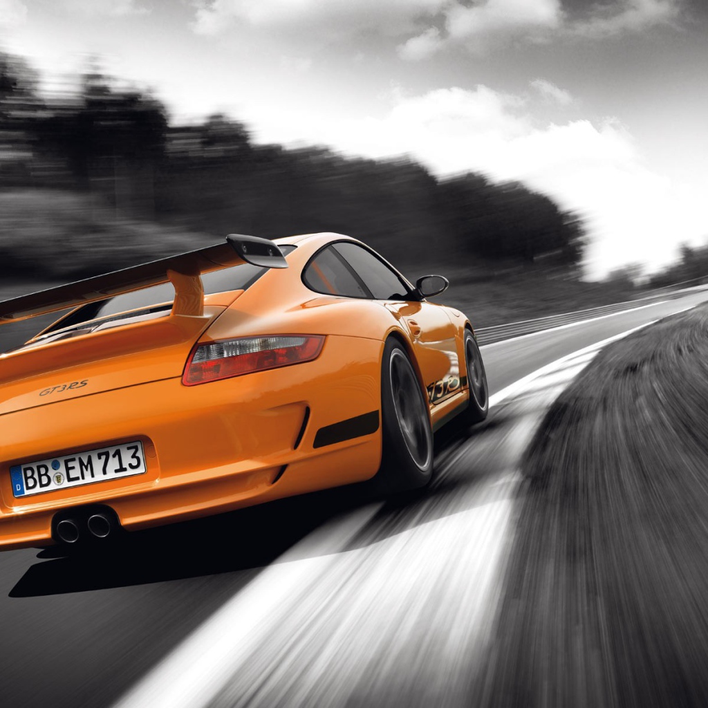 Оранжевый Porsche GT3RS на сером шоссе
