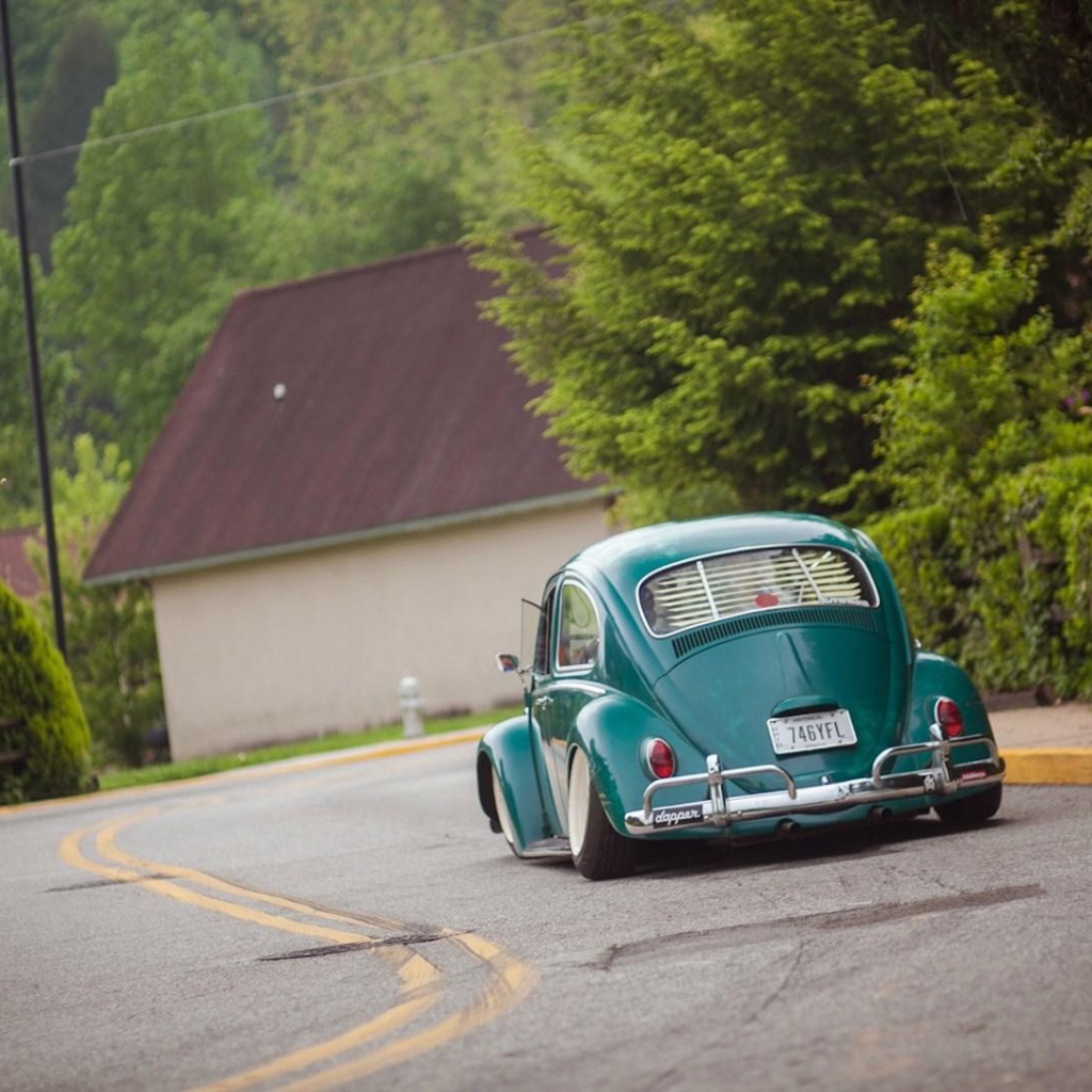 Зеленый Volkswagen Beetle на дороге