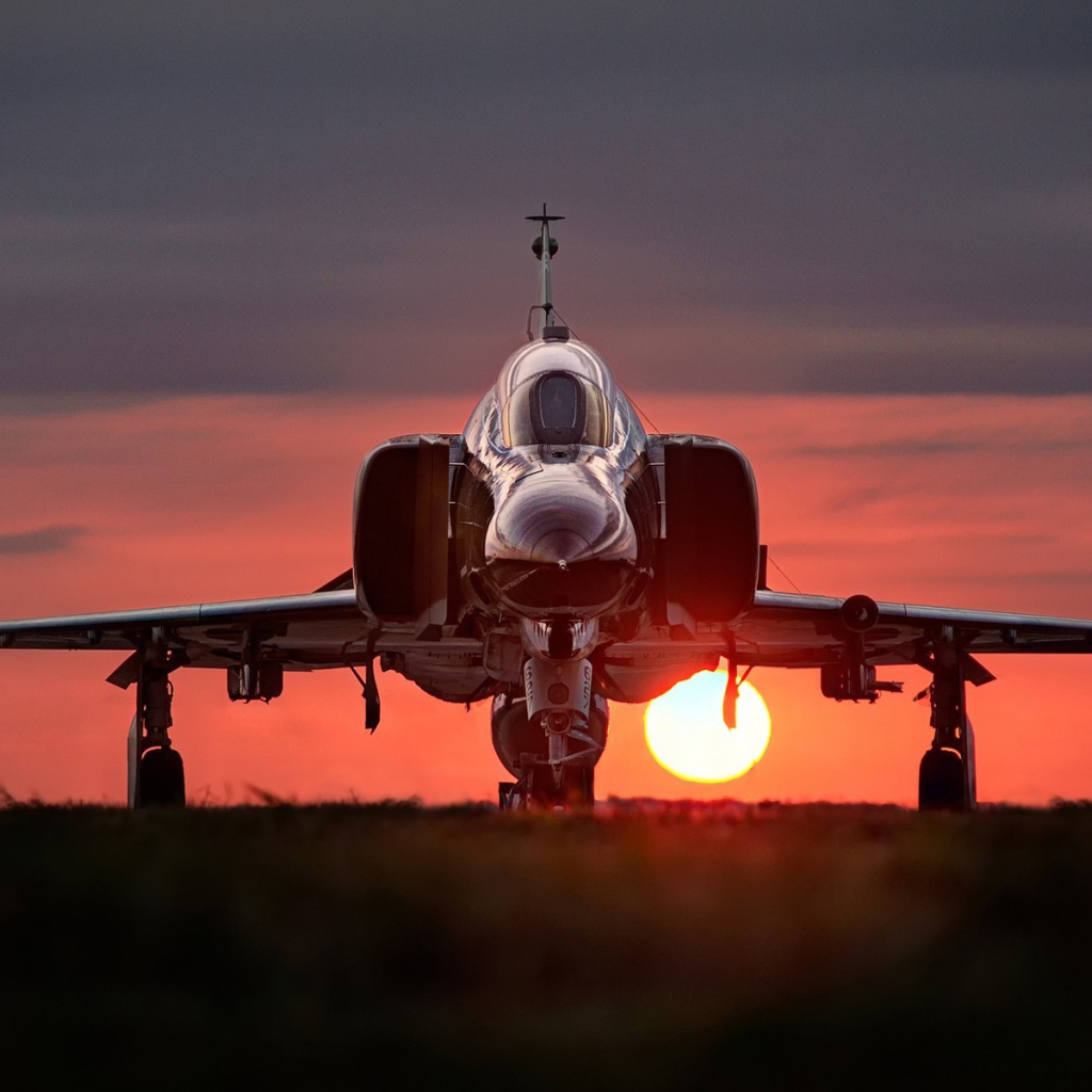 Истребитель F-4 Phantom II стоит на фоне заката