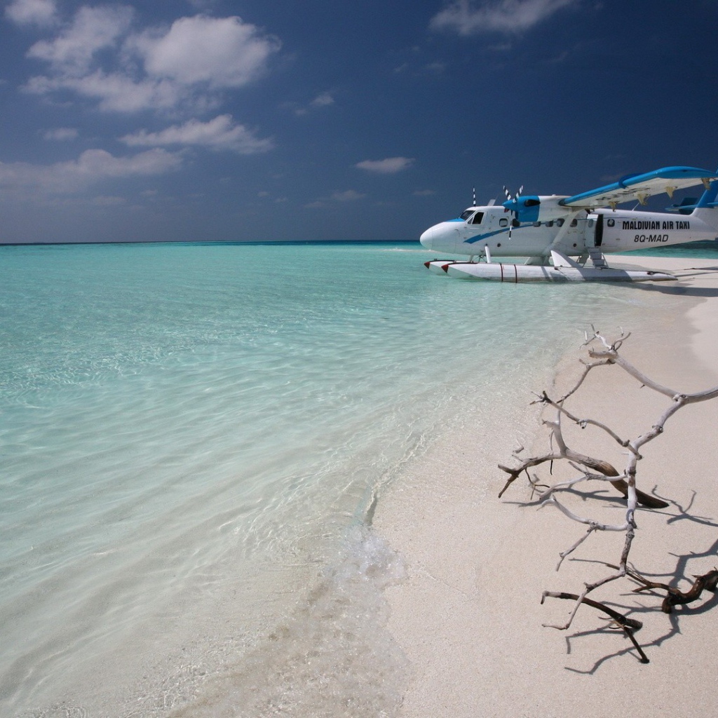 Самолет сел на воду у белого пляжа