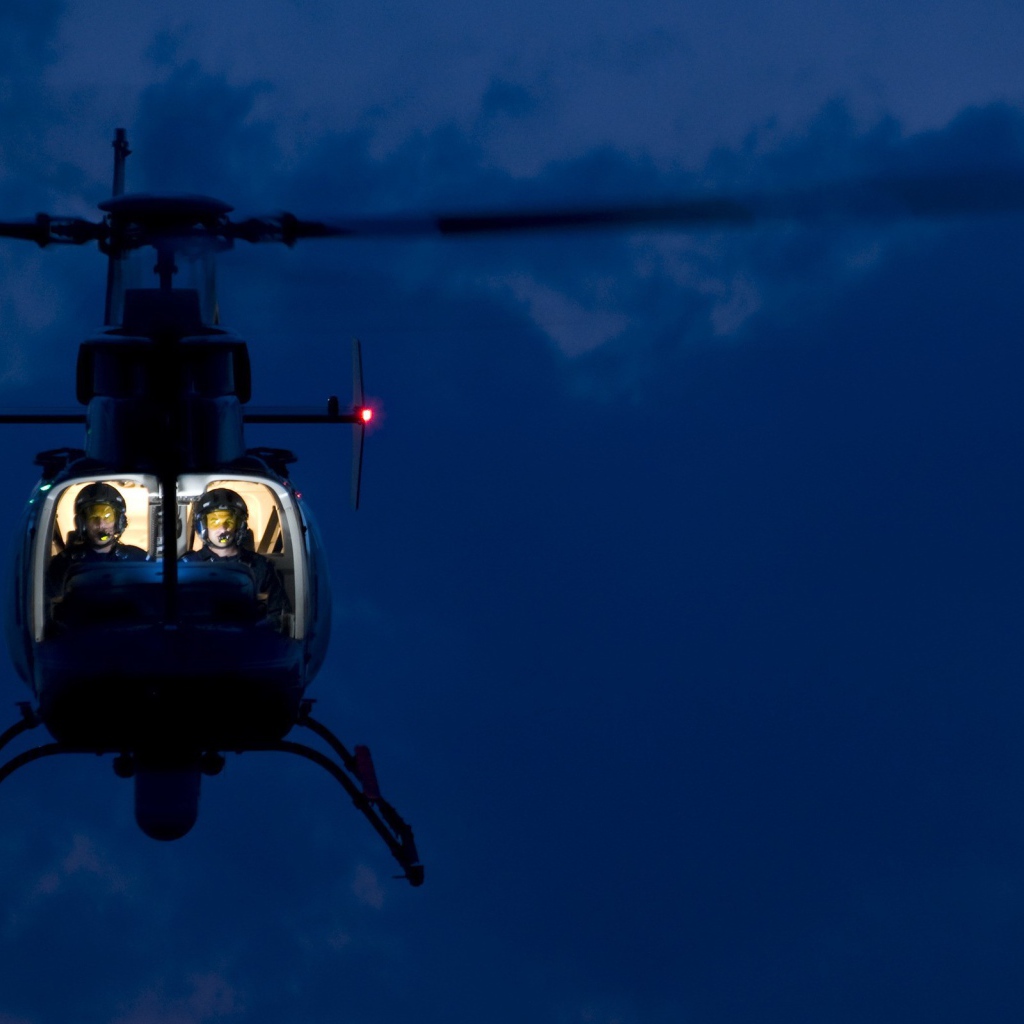 Двое в вертолете на фоне синего неба