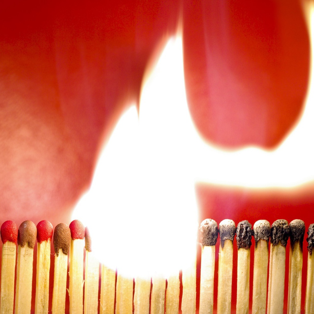 Горящий ряд спичек на красном фоне